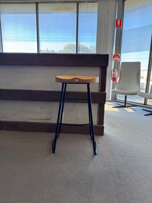 Small wooden table with metal legs in a room with large windows