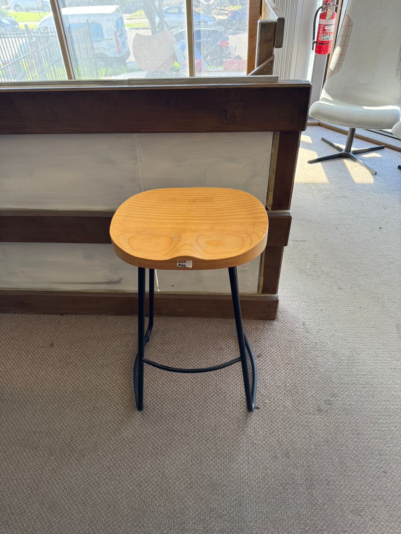 Wooden stool with a blue metal frame in an indoor setting