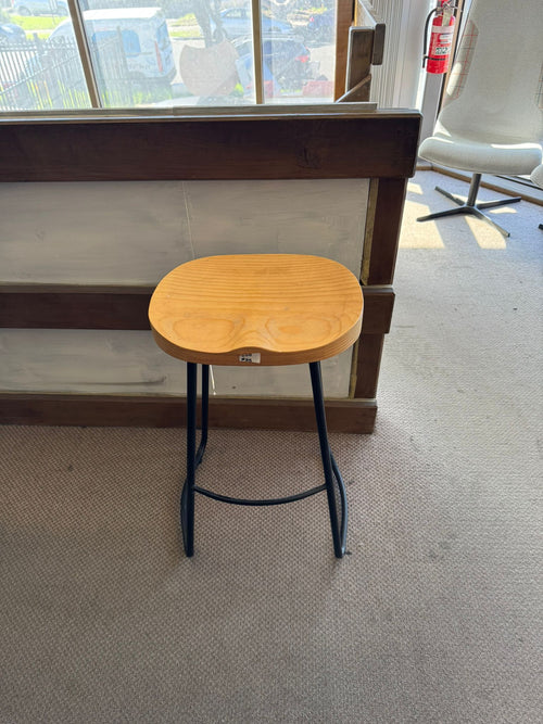 Wooden stool with a blue metal frame in an indoor setting