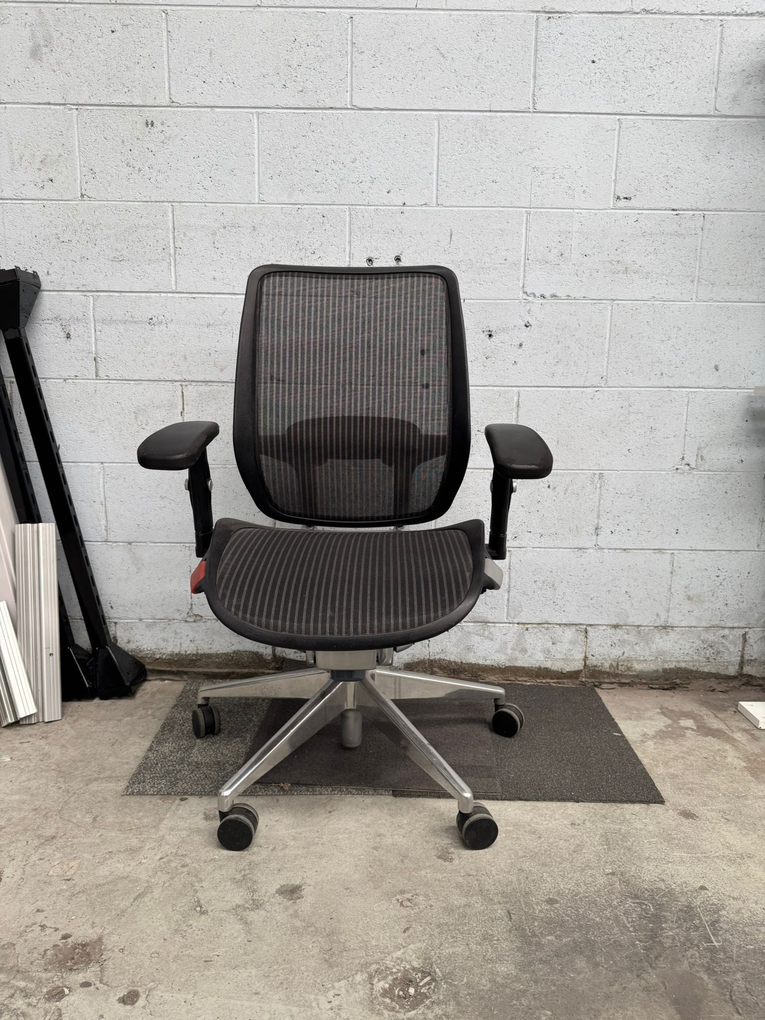 Black office chair in a room with concrete floor and wall