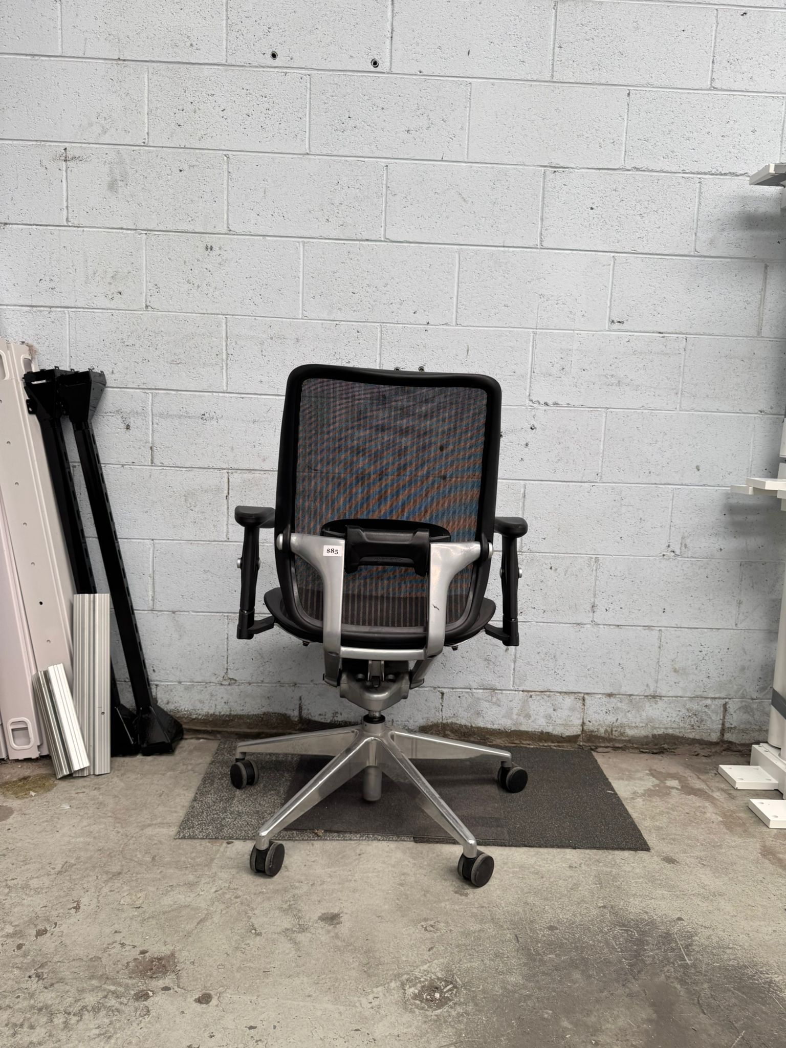 Black office chair in a room with concrete floor and wall