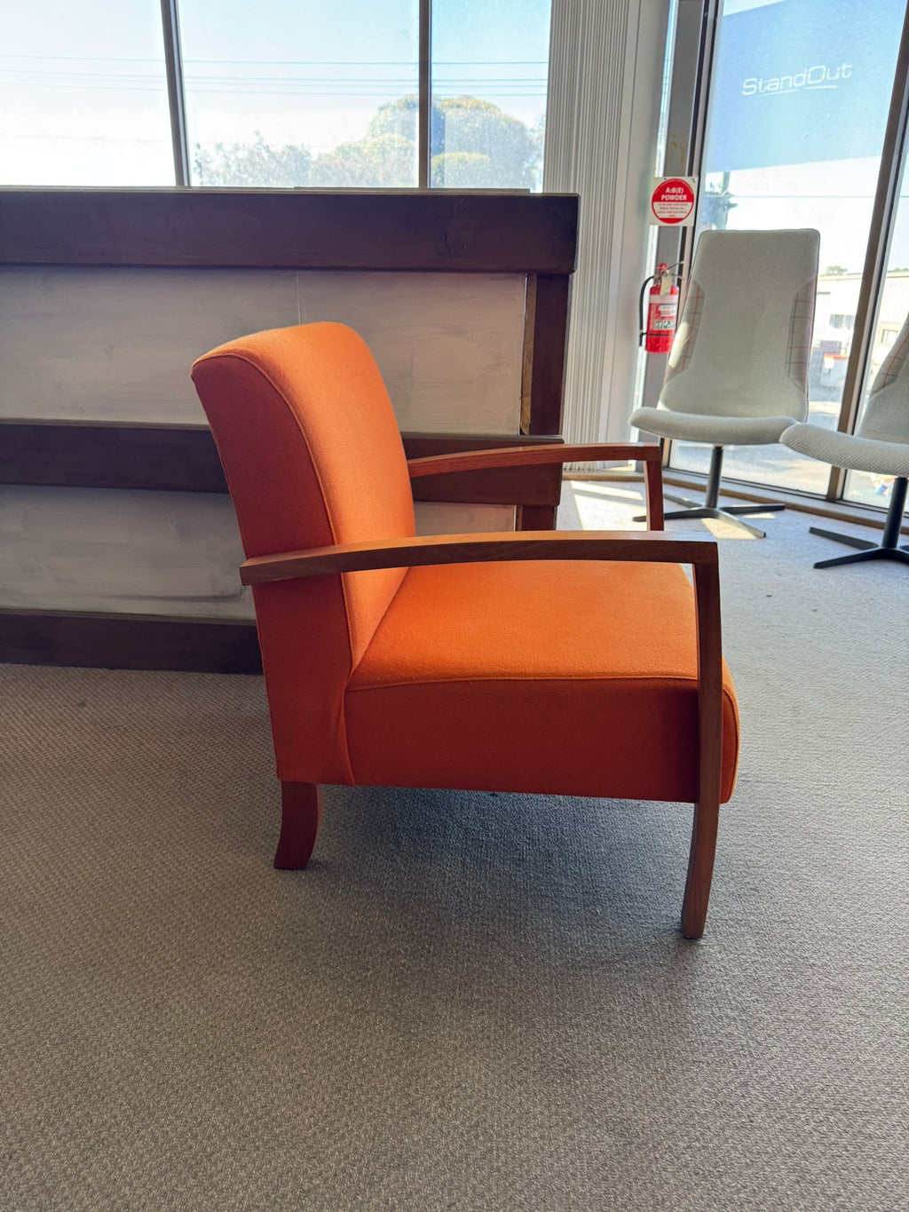Orange armchair in a room with large windows