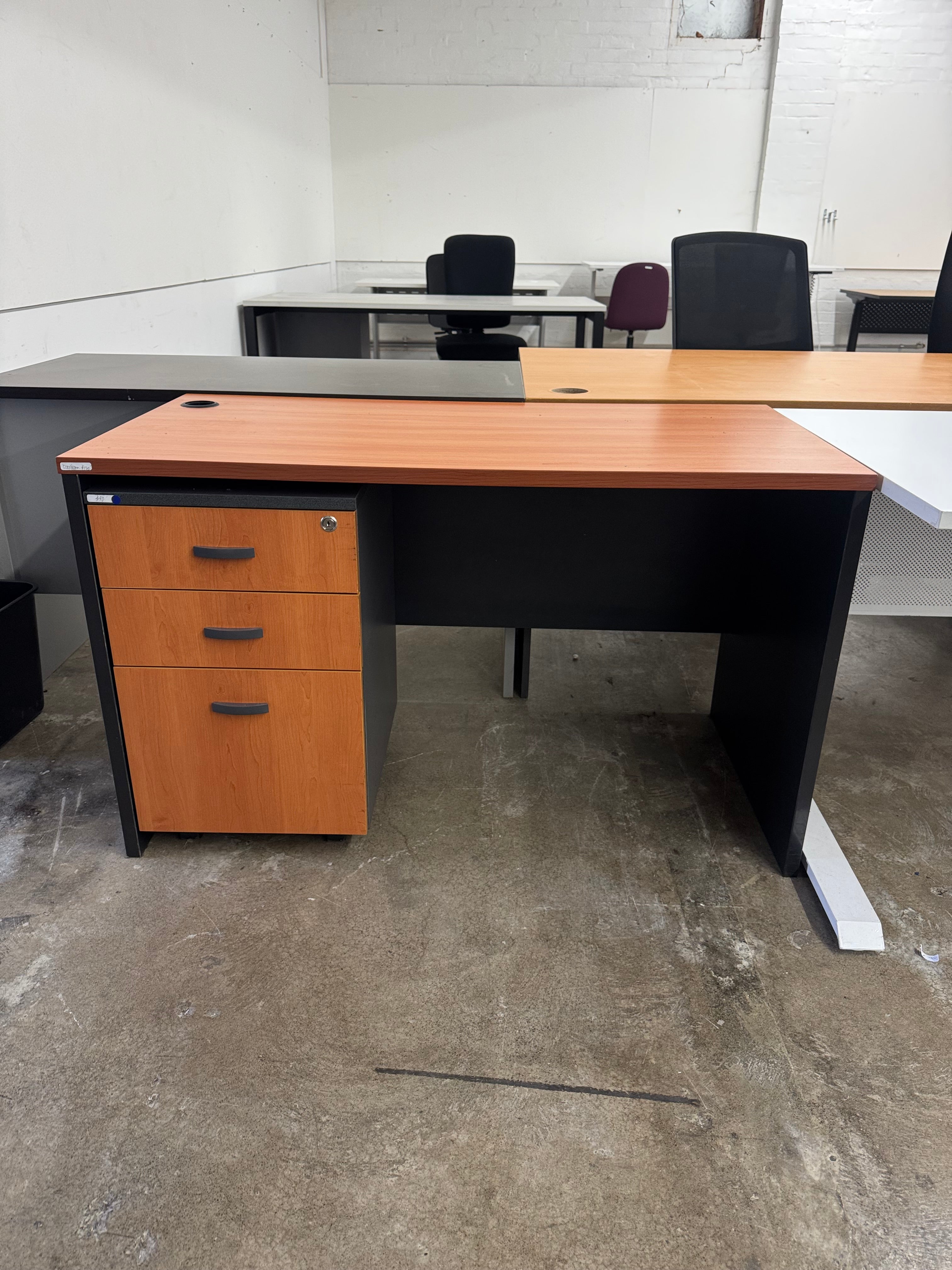 Wooden office desk with black frame in an indoor setting