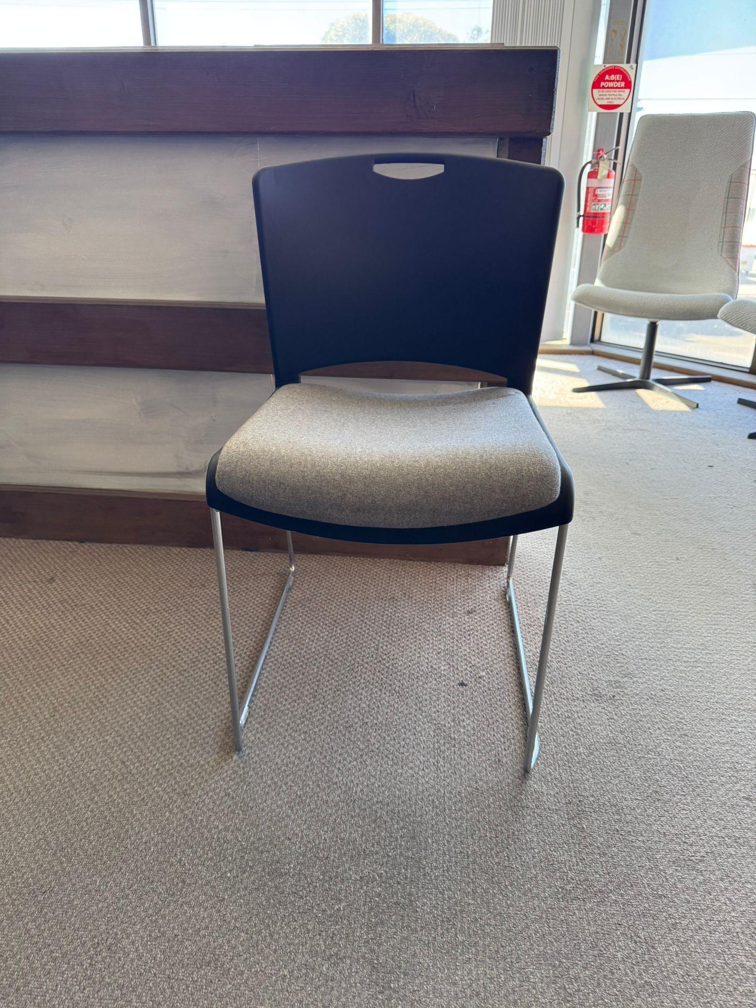 Blue chair with a beige cushion on a carpeted floor.